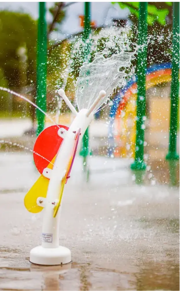 Close-up of a commercial spray park equipment component splashing water, featuring durable, interactive aquatic play features for municipal water parks