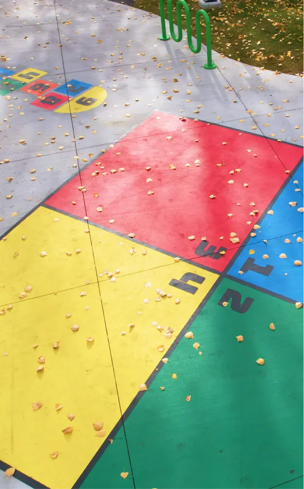 Vibrant, multi-colored TuffCoat safety surfacing professionally installed by the Parkcraft team to provide impact attenuation and slip resistance for a modern playground